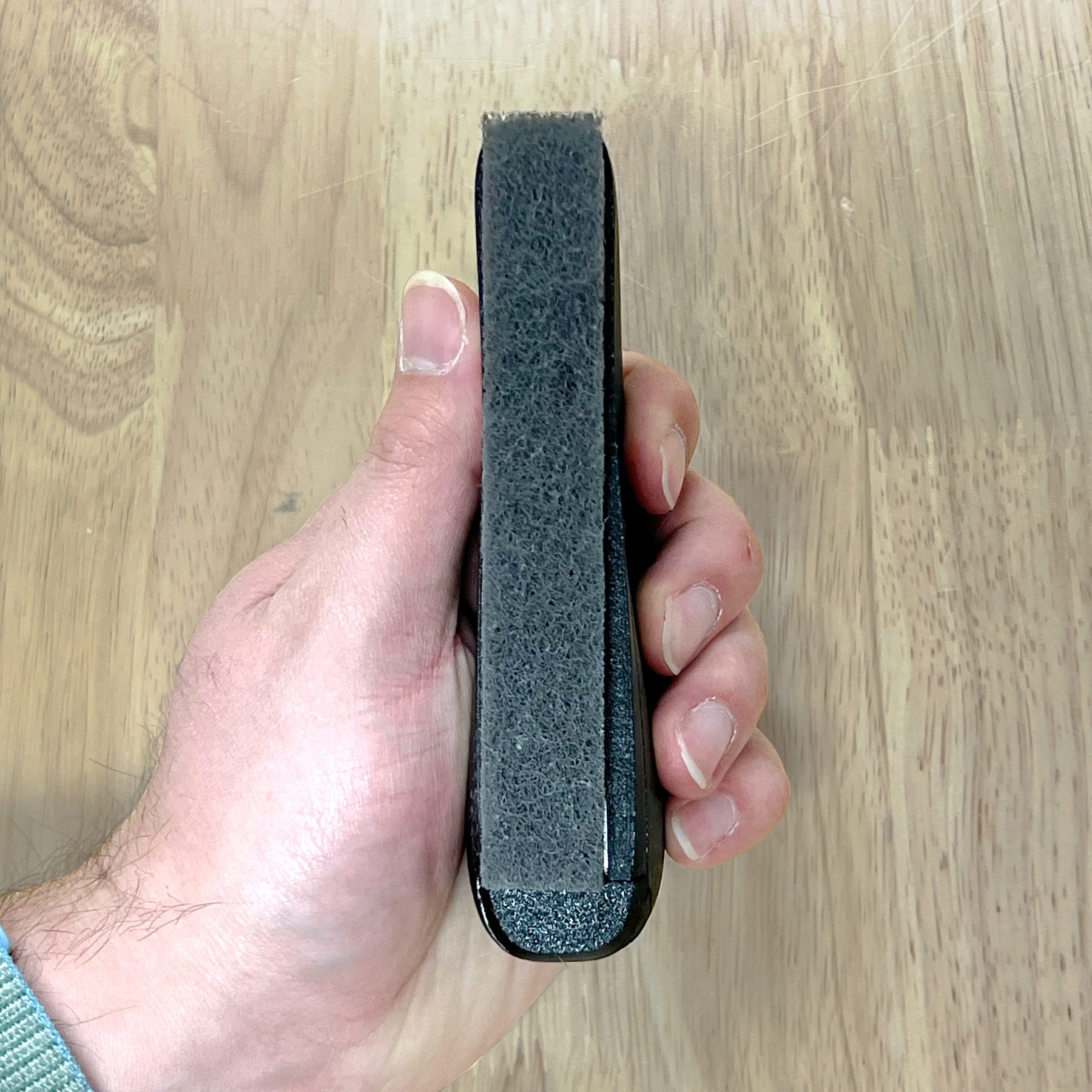 Side view of the brush held in hand showing the pad edge